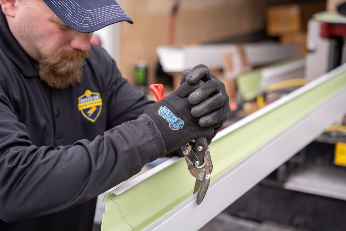 Technician cutting Gutters to size